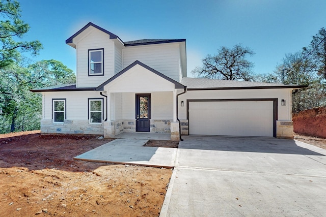 view of front of home with an attached garage, stone siding, and driveway