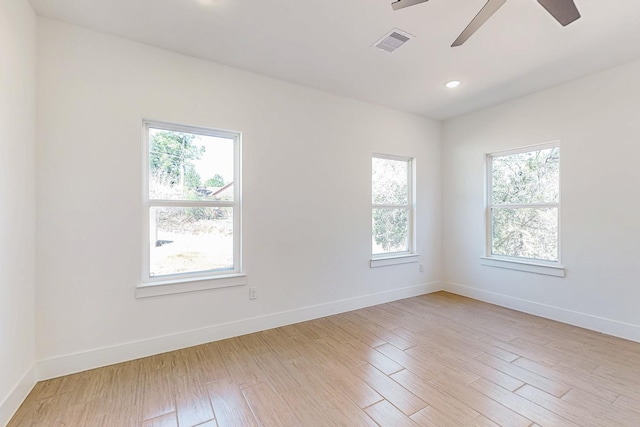 unfurnished room with baseboards, visible vents, and light wood finished floors