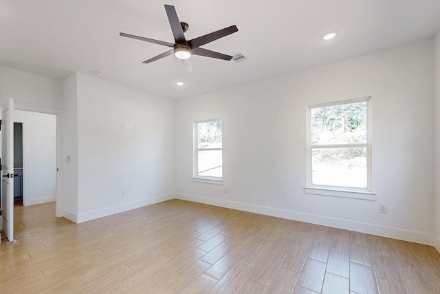 spare room featuring baseboards, visible vents, and light wood finished floors