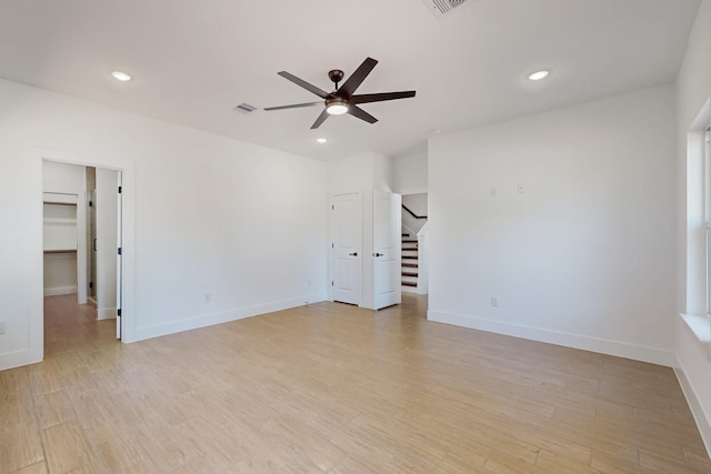 spare room with stairs, recessed lighting, light wood-style floors, and baseboards