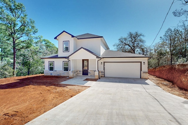 view of front of property featuring stone siding, concrete driveway, and an attached garage