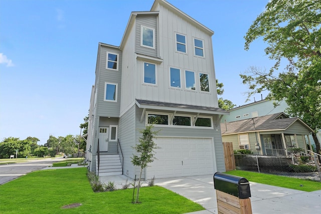 view of front facade featuring board and batten siding, fence, a front yard, a garage, and driveway