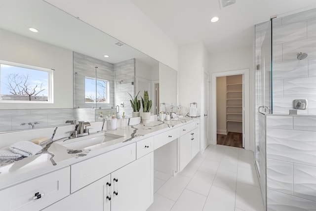 bathroom featuring recessed lighting, vanity, a stall shower, and a spacious closet