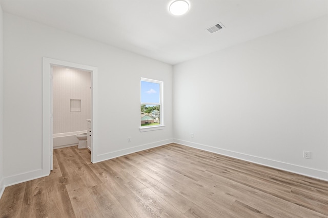 unfurnished room featuring light wood-style flooring, baseboards, and visible vents