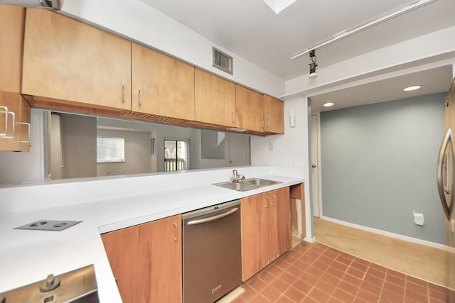 kitchen featuring visible vents, a sink, light countertops, rail lighting, and stainless steel dishwasher