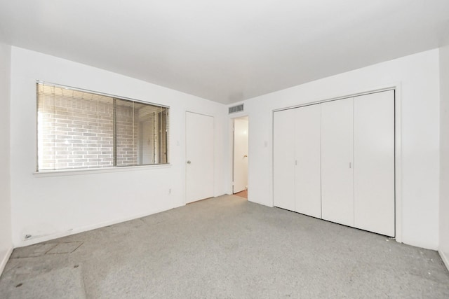 unfurnished bedroom featuring visible vents, carpet, and a closet