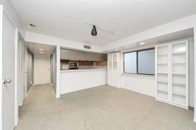 unfurnished living room featuring recessed lighting, visible vents, light colored carpet, and rail lighting