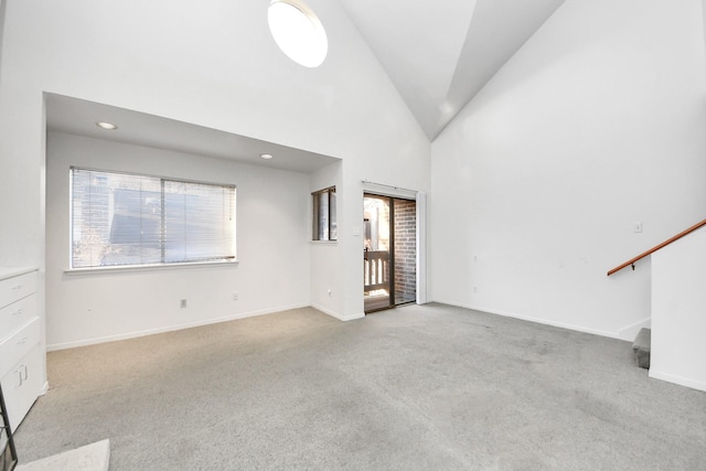 unfurnished living room featuring stairway, baseboards, high vaulted ceiling, and carpet flooring