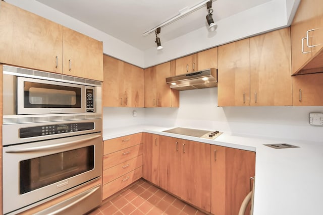 kitchen with light countertops, a warming drawer, under cabinet range hood, and stainless steel appliances