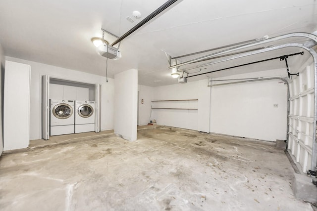 garage with a garage door opener and washer and clothes dryer