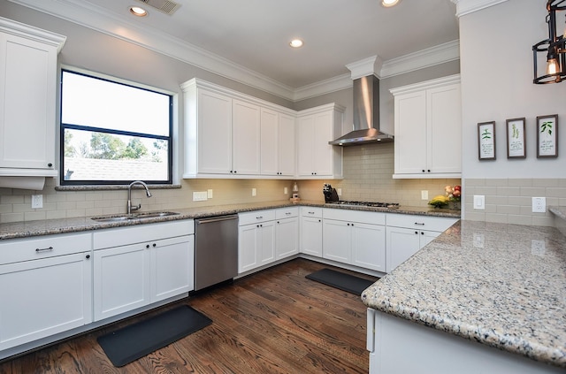 kitchen featuring white cabinets, stainless steel appliances, wall chimney range hood, and a sink