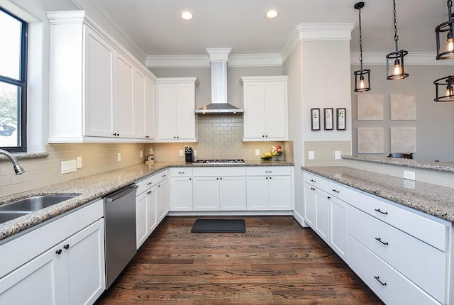 kitchen with a sink, crown molding, wall chimney range hood, appliances with stainless steel finishes, and dark wood-style flooring