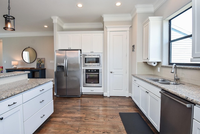 kitchen with ornamental molding, a sink, appliances with stainless steel finishes, decorative backsplash, and dark wood-style flooring