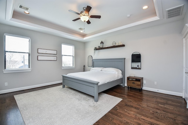 bedroom featuring a tray ceiling, baseboards, and visible vents