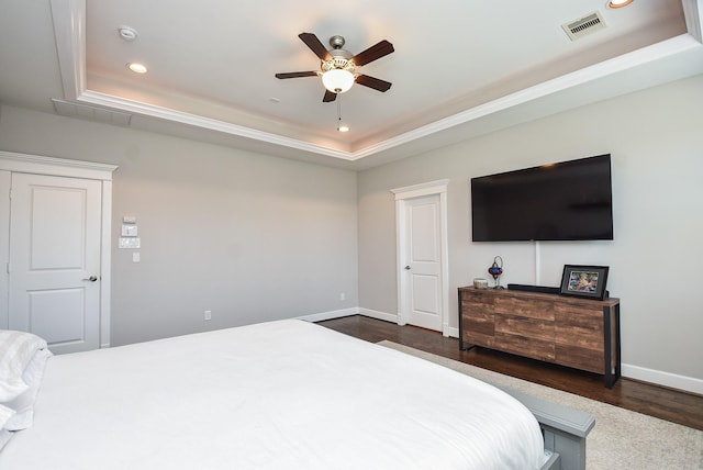 bedroom with visible vents, dark wood-type flooring, recessed lighting, baseboards, and a raised ceiling