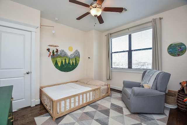 bedroom with a ceiling fan, baseboards, and wood finished floors