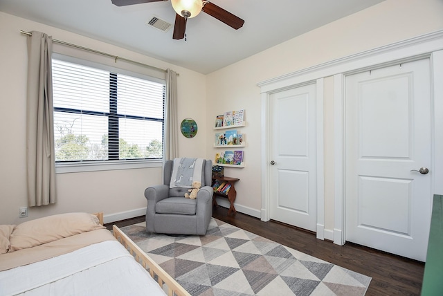 bedroom with ceiling fan, visible vents, baseboards, and dark wood-style floors