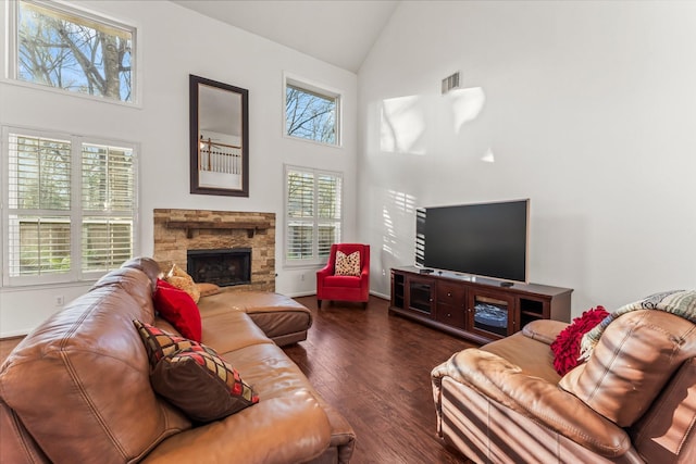 living area featuring visible vents, baseboards, a fireplace, high vaulted ceiling, and wood-type flooring