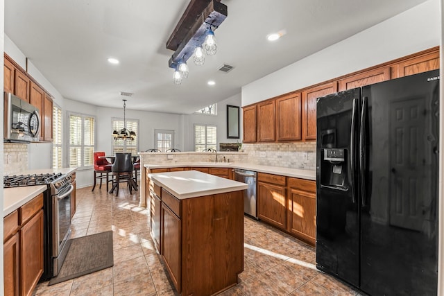 kitchen featuring stainless steel appliances, visible vents, decorative backsplash, and light countertops