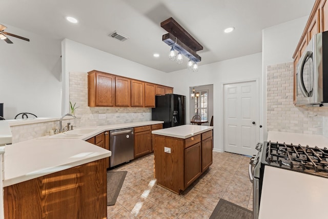 kitchen featuring visible vents, brown cabinets, a sink, a center island, and appliances with stainless steel finishes