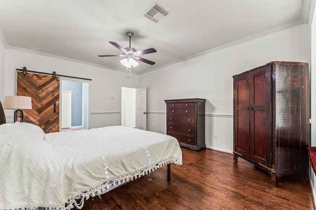 bedroom with visible vents, crown molding, dark wood-type flooring, and a barn door