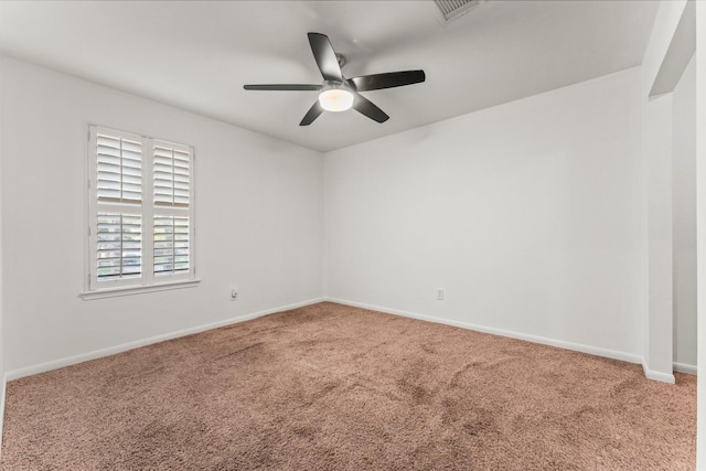 carpeted spare room featuring a ceiling fan, baseboards, and visible vents