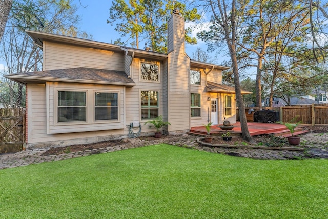 rear view of property with fence, a yard, a shingled roof, a wooden deck, and a chimney