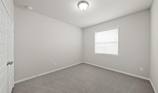 carpeted empty room with baseboards