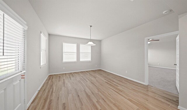 empty room with baseboards and light wood-type flooring