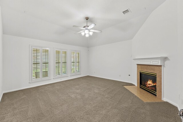 unfurnished living room featuring visible vents, carpet flooring, a tile fireplace, and lofted ceiling