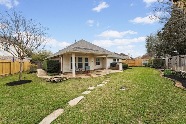 back of house with a patio, a fenced backyard, a lawn, and roof with shingles