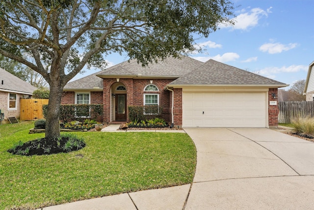 view of front of property with brick siding, concrete driveway, a front yard, and fence