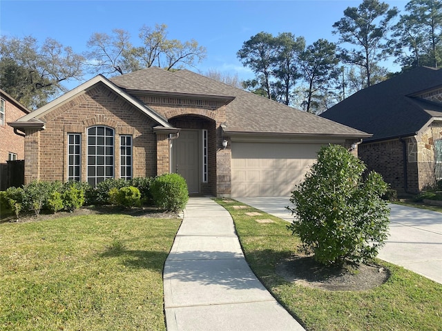 view of front of property featuring brick siding, driveway, a shingled roof, and a front lawn