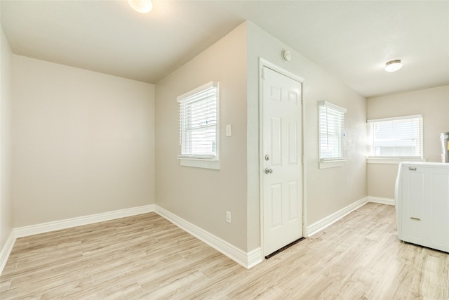laundry room featuring light wood finished floors, laundry area, washer / clothes dryer, and baseboards