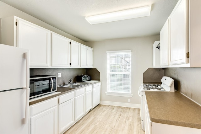 kitchen featuring white appliances, white cabinetry, and light wood-type flooring