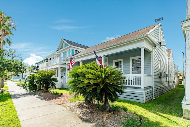 exterior space featuring covered porch, a front yard, and a garage