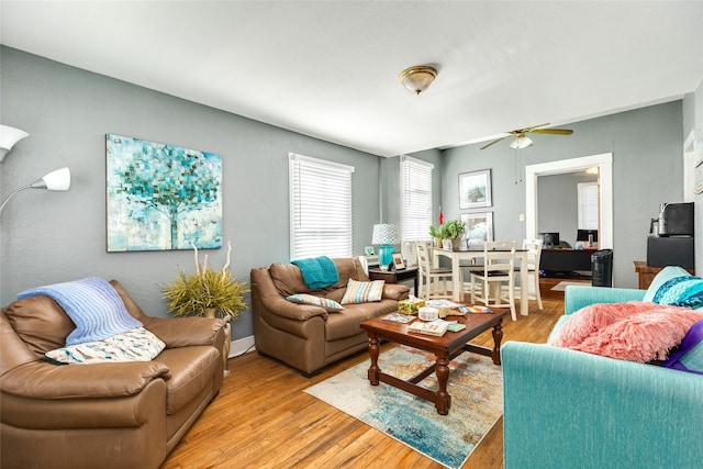 living area with light wood finished floors and a ceiling fan