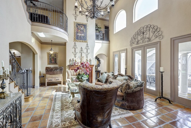 tiled foyer entrance featuring crown molding, stairway, arched walkways, and a wealth of natural light