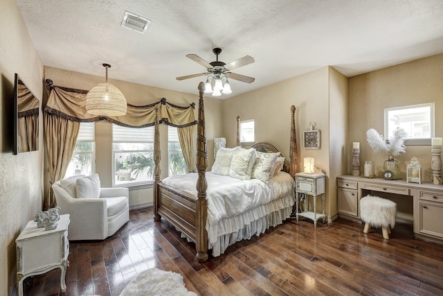 bedroom featuring visible vents, dark wood-style flooring, and a textured ceiling