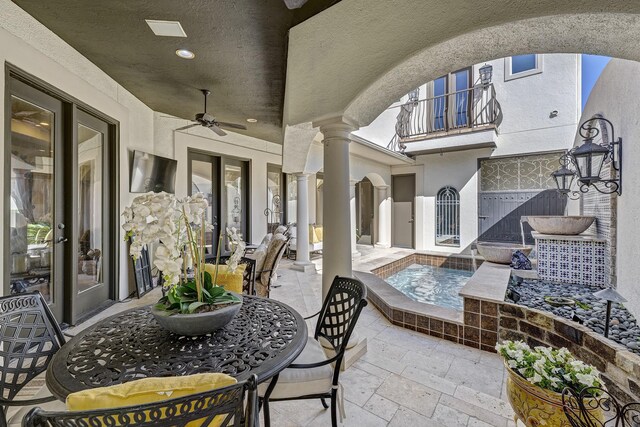 view of patio / terrace with a jacuzzi, a balcony, and a ceiling fan