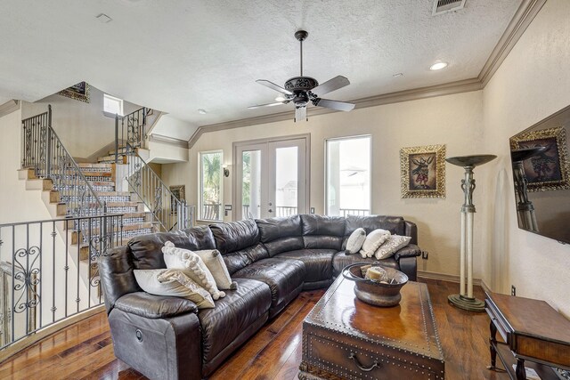 living area with dark wood-style floors, french doors, a textured ceiling, and ornamental molding