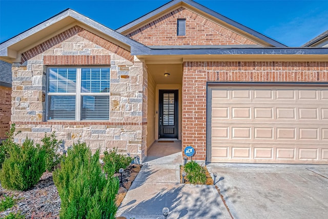 view of front of property featuring brick siding, stone siding, an attached garage, and driveway