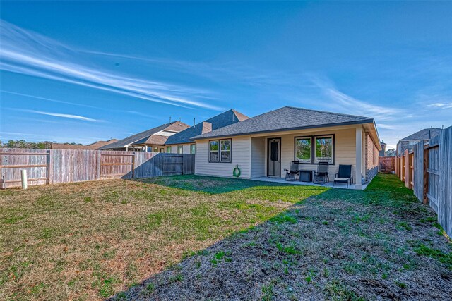 back of property with a patio, a lawn, a fenced backyard, and a shingled roof