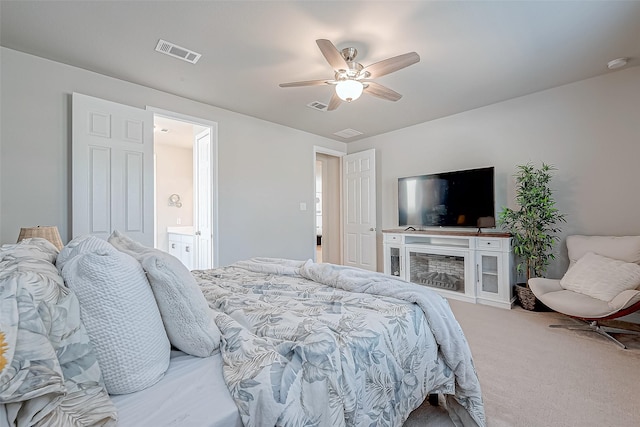 carpeted bedroom featuring visible vents, connected bathroom, and a ceiling fan