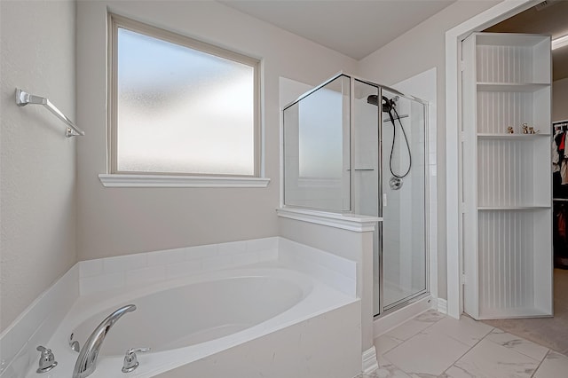 full bath featuring a garden tub, a spacious closet, a stall shower, and marble finish floor