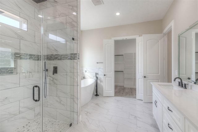 bathroom with vanity, visible vents, a freestanding bath, a shower stall, and marble finish floor