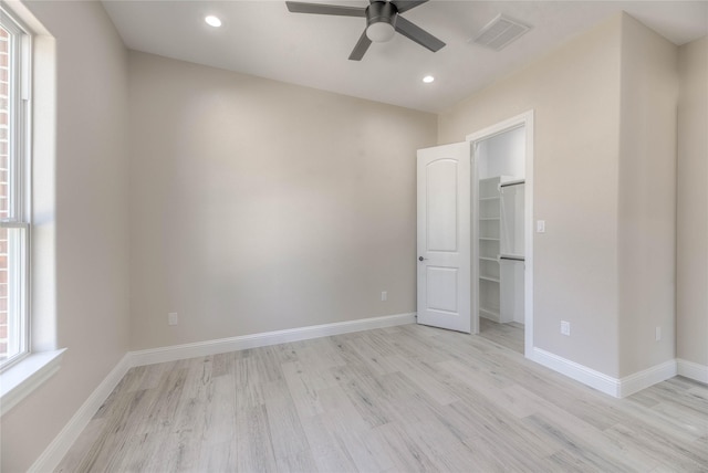 unfurnished bedroom featuring visible vents, recessed lighting, light wood finished floors, baseboards, and a spacious closet