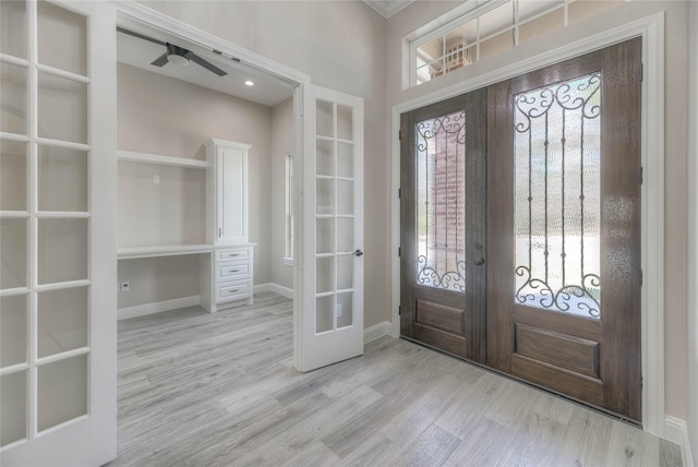 foyer featuring french doors, baseboards, and light wood-style floors