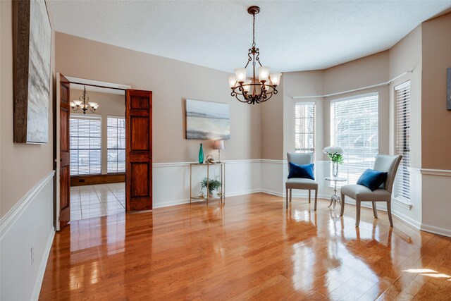 sitting room featuring a notable chandelier and light wood-type flooring