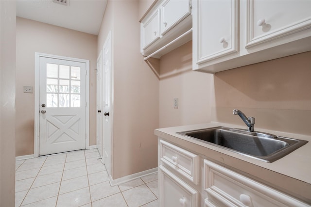 kitchen featuring light tile patterned floors, visible vents, a sink, light countertops, and white cabinets